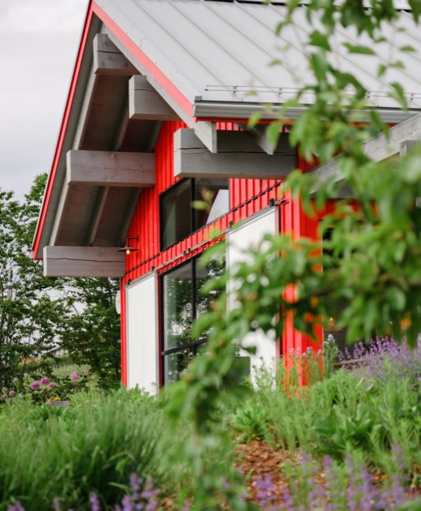 JoieFarm red farmhouse among greenery and lavender.