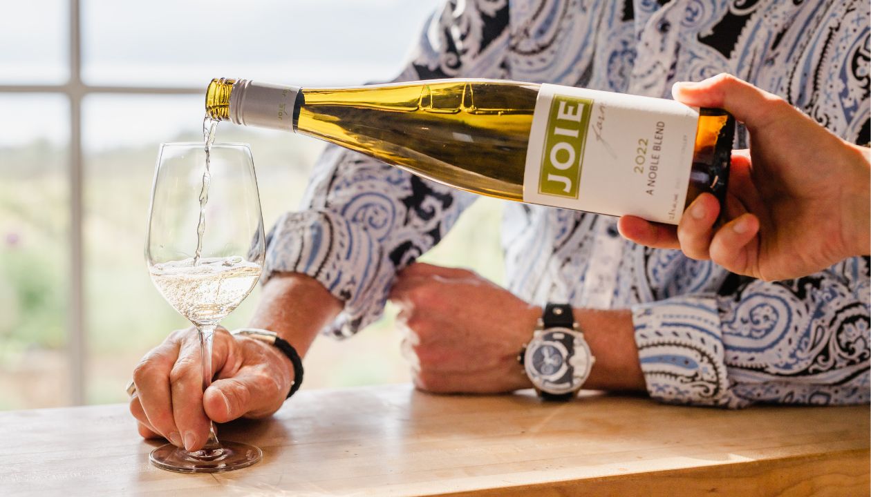 Pouring a glass of 2022 JoieFarm A Noble Blend wine in the tasting room.