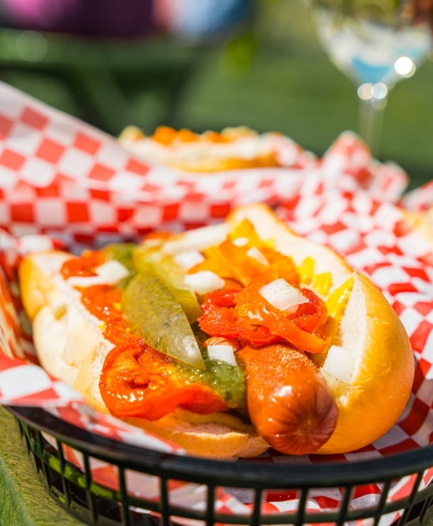 Hotdog with banana peppers, onions, mustard and pickle